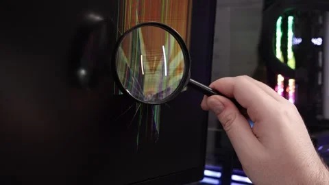 Technician's hand with magnifying glass examines a cracked computer display.. Stock Footage 324964465