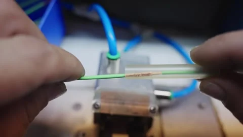 Technician's hands assembling a fiber optic cable, showcasing precision and e Stock Footage 319503949