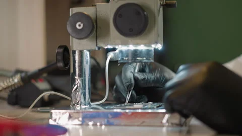 Technician's Hands in Black Gloves Working on Circuit Board Under Microscope Video stock 283120203