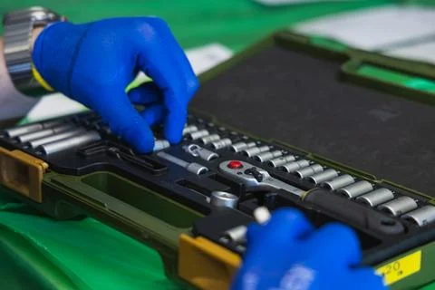 Technician's hands pick up a screwdriver from a toolbox Stock Photos