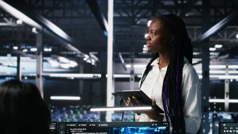 Technicians in high tech data center cooperate on neural network software Stock Footage 313566325