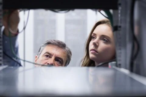 Technicians looking into empty server towers Stock Photos