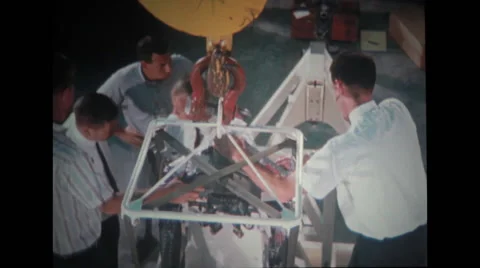 Technicians moving spacecraft couch towards stand Stock Footage