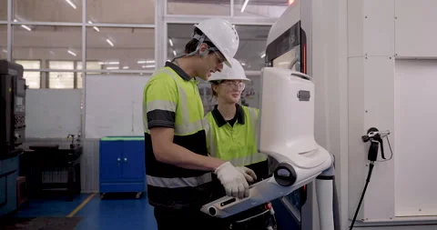 Technicians operating advanced cnc machine interface together during automation Stock Footage 316077087