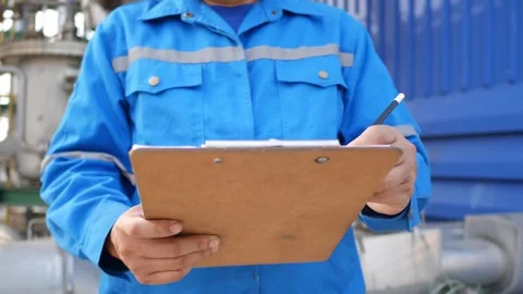 Technicians perform daily machinery checks in an industrial plant and log result Stockbeeldmateriaal 304070754