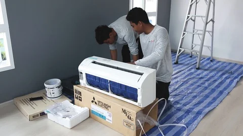 Technicians preparing an air conditioner for installation Stock Footage 98451274