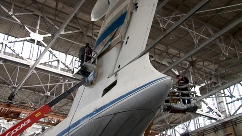 Technicians put identification mark on keel Il-76 while in elevator basket. Stock Footage 108430019