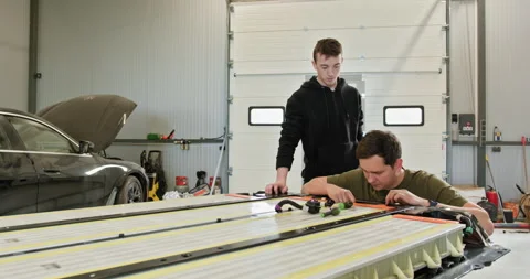 Technicians Repairing Lithium-Ion Battery In Car Workshop Stock Footage 277323310