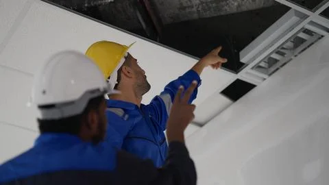 Technicians with safety helmet working installing and checking system Stock Photos