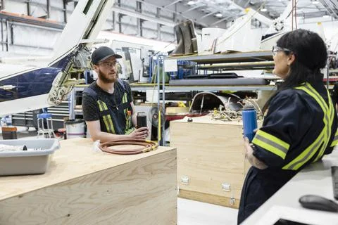 Technicians taking break in helicopter hangar Stock Photos