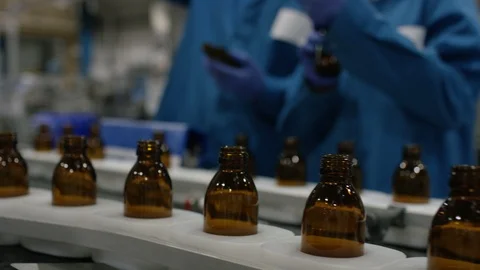 Technicians talking to production workers while inspecting bottles Stock Footage 107953304