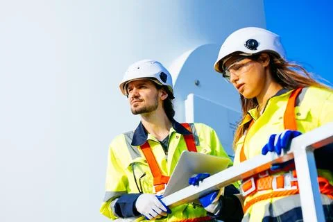 Technicians team with safety uniform working at wind turbine field Stock-Fotos
