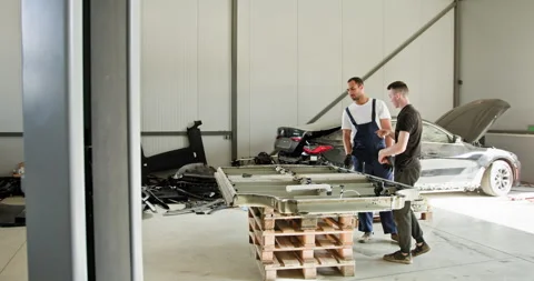 Technicians Troubleshooting EV Car Battery Module in Workshop Stock Footage 277229238