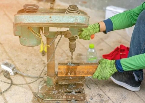 Technicians use an old drill to drill steel. Stock Photos