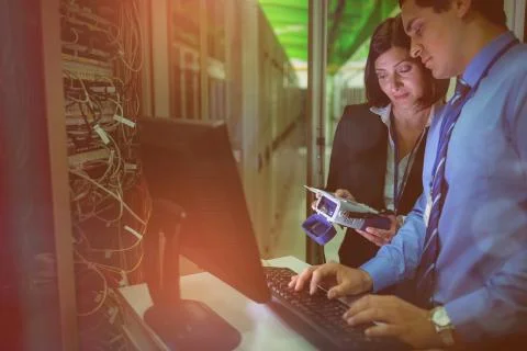 Technicians using digital cable analyzer while working on personal computer Fotos Stock