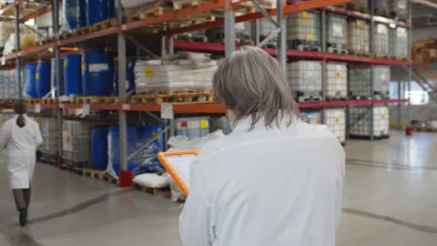 Technicians in white coat walking in modern chemical factory warehouse Stock Footage 143565095