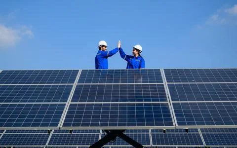 Technicians workers team installing solar panels at industrial solar cell farm Stock Photos
