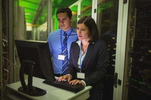 Technicians working on personal computer while analyzing server Foto stock