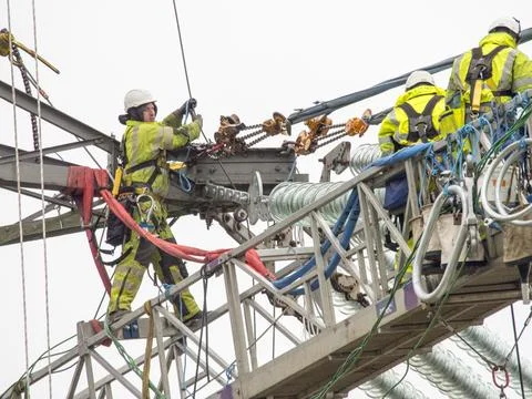 Technicians working to replace old insulators on a pylon in Barrow on Soar, L Foto stock