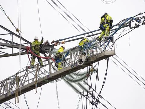 Technicians working to replace old insulators on a pylon in Barrow on Soar, L Stock Photos