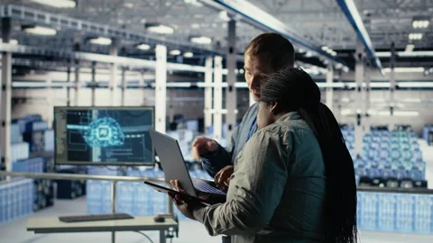 Technicians working together in server room, optimizing deep learning AI systems Stock Footage 314685689