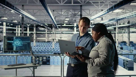 Technicians working together in server room, optimizing deep learning AI systems Stock Footage 314805535