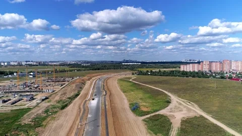 Technique is asphalting a section of road near a new district - Drone footage Stock Footage 142991933