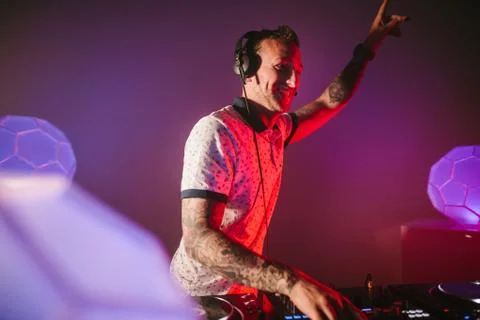 Techno DJ dancing to the crowd in a red background Foto stock
