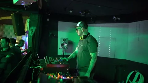 Techno dj operating mixer and turntables during a nightlife party inside a Stock Footage 331566013