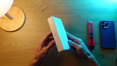 Technoblogger unpacks a box with a new google piel 6a phone Stock Footage 252770508