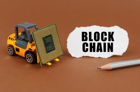 Technological concept. On a brown surface, a forklift is transporting a proce Stock Photos