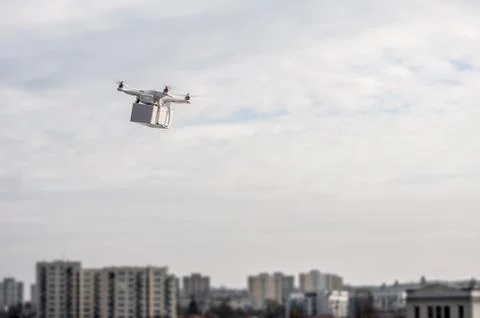 Technological delivery innovation - fast drone delivery concept above town Stock Photos