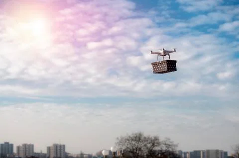 Technological delivery innovation - fast drone delivery concept above town Stock Photos