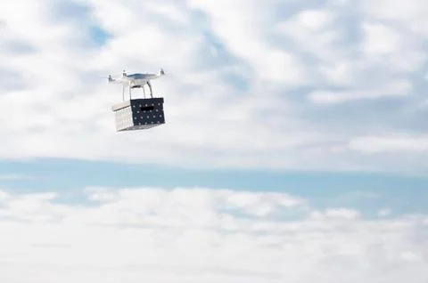 Technological delivery innovation - fast drone delivery concept above town Stock Photos