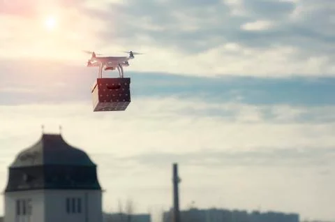 Technological delivery innovation - fast drone delivery concept above town Stock Photos