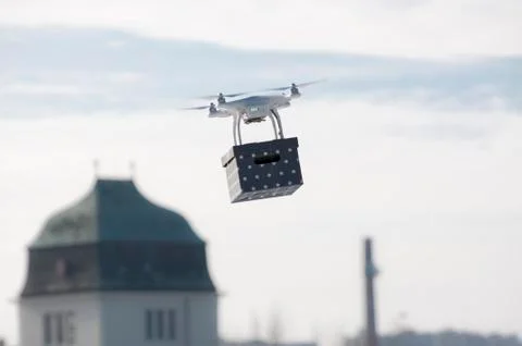 Technological delivery innovation - fast drone delivery concept above town Stock Photos