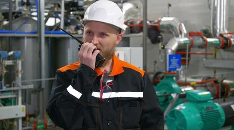 Technological engineer in a white helmet transmits instructions to the staff Stock Photos