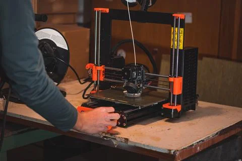 Technological hi-teg tool for making new things. A black and red 3D printer a Stock Photos