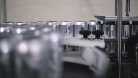 Technological line for bottling of beer in brewery. Empty aluminum beer cans are Stock Footage 129305840