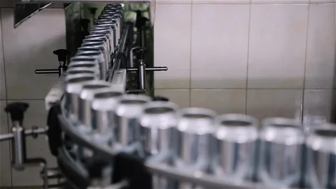 Technological line for bottling of beer in brewery. Empty aluminum beer cans are Stockbeeldmateriaal 129306250