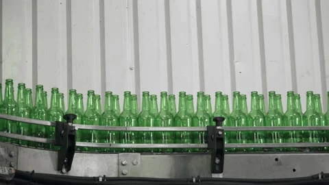 Technological line for bottling of beer in brewery. Empty green bottles in a Vidéo 151813640