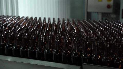 Technological line for bottling of beer in brewery. Empty brown bottles in a Stock Footage 156257803