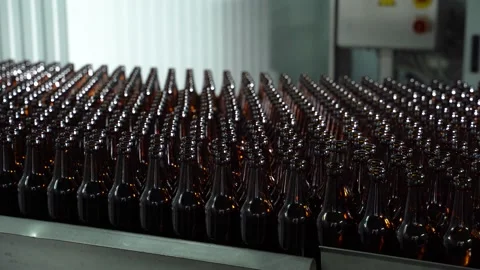 Technological line for bottling of beer in brewery. Empty brown bottles in a Stock Footage 156749384