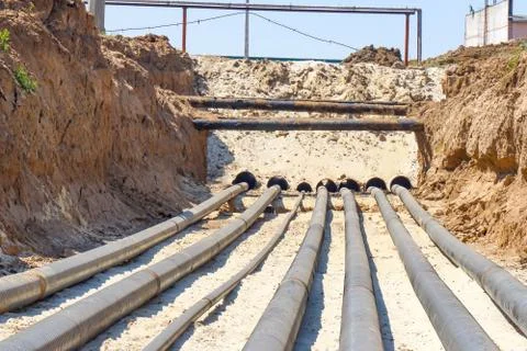 Technological pipelines DN50 and DN150 in isolation in the trench go into the Stock Photos