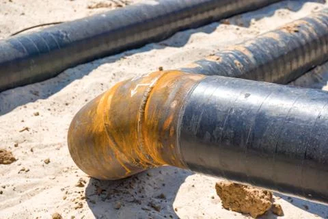 Technological pipelines DN50 and DN150 in isolation in the trench go into the Stock Photos