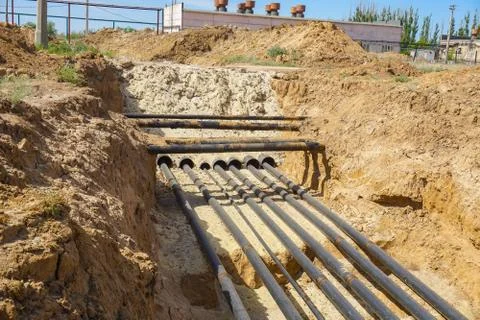 Technological pipelines DN50, DN80 and DN150 in isolation in the trench go in Stock Photos