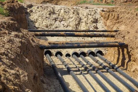 Technological pipelines DN50, DN80 and DN150 in isolation in the trench go in Stock Photos
