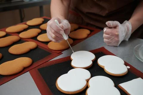 Technological process of production of gingerbread. The confectioner corrects Stock Photos