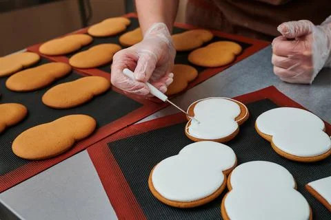 Technological process of production of gingerbread. The confectioner corrects Stock Photos