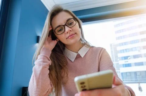 Technological progress or social media problem: young mixed-race female hol.. Stock Photos